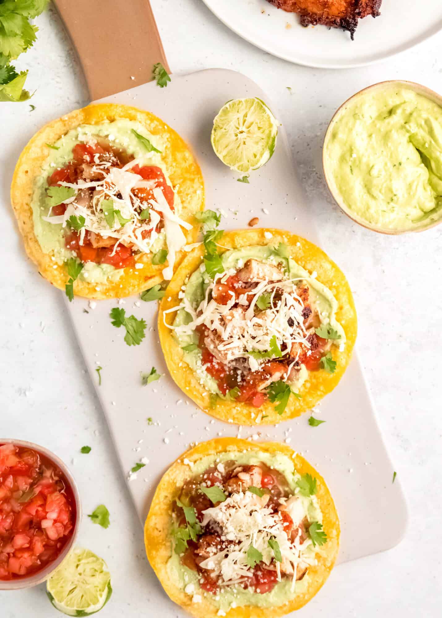 three chicken tostadas with avocado crema and salsa